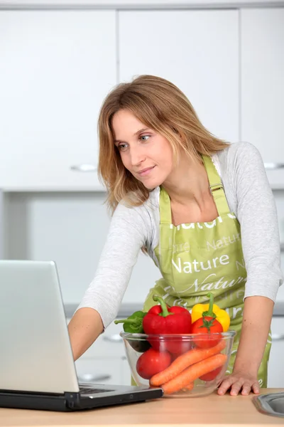 Vrouw in keuken op zoek naar koken receipe — Stockfoto