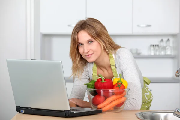 Vrouw in keuken op zoek naar koken receipe — Stockfoto