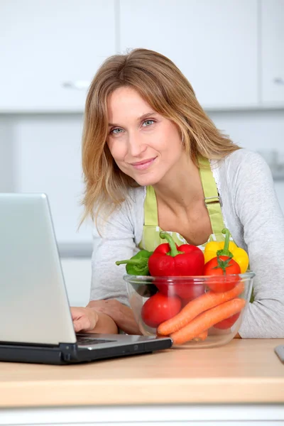 Mujer en la cocina en busca de receptor de cocina — Foto de Stock