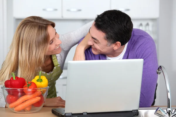 Paar in Küche sucht Kochrezepte — Stockfoto