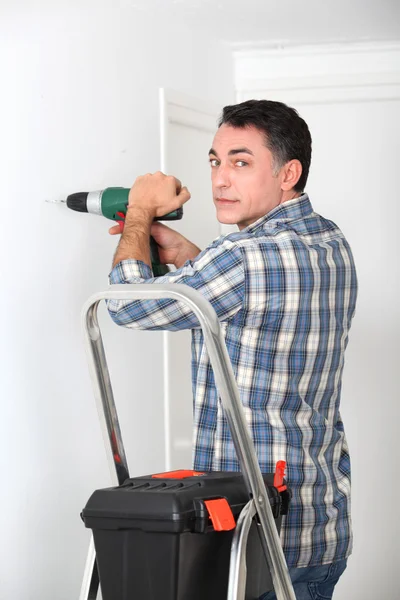 Homem usando broca elétrica em casa — Fotografia de Stock