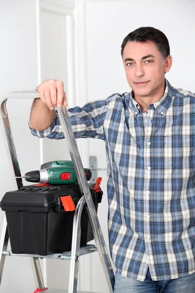 Uomo che utilizza trapano elettrico a casa — Foto Stock