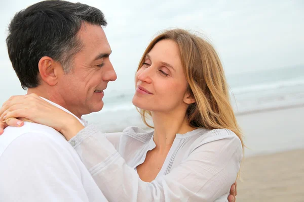 Paar omhelzen elkaar op het strand — Stockfoto