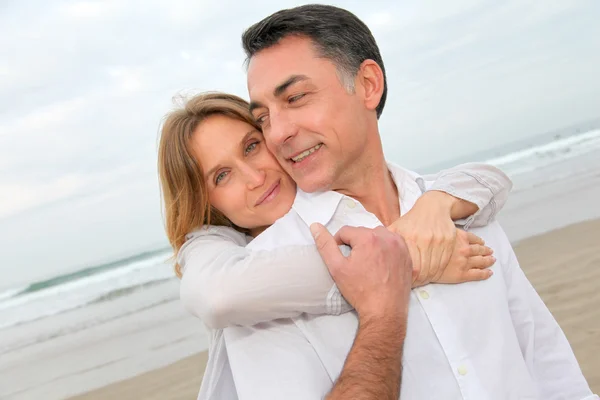 Casal abraçando uns aos outros na praia — Fotografia de Stock