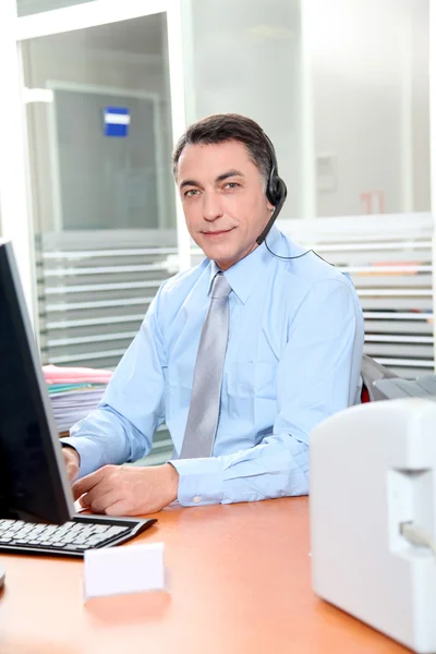 Vuxen man på kontoret talar i telefon — Stockfoto