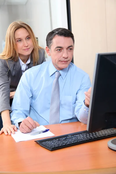 Менеджер и сотрудник перед компьютером в офисе — стоковое фото