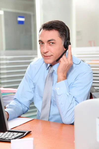 Взрослый мужчина в офисе разговаривает по телефону — стоковое фото