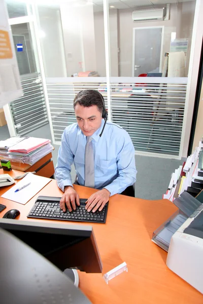 Vuxen man på kontoret talar i telefon — Stockfoto