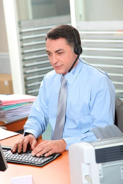 Vuxen man på kontoret talar i telefon — Stockfoto