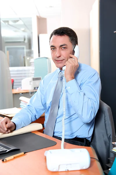 Homem de negócios no escritório falando ao telefone — Fotografia de Stock