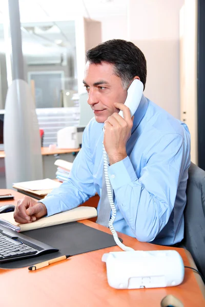 Homem de negócios no escritório falando ao telefone — Fotografia de Stock