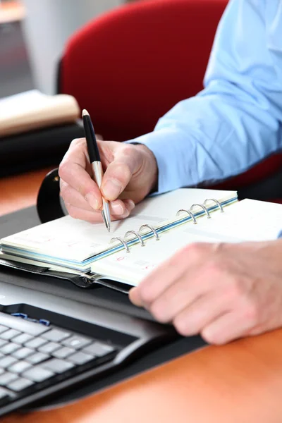 Primer plano de la escritura del hombre en la agenda — Foto de Stock