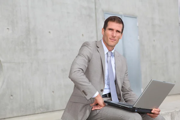 Zakenman zitten buiten met laptopcomputer — Stockfoto