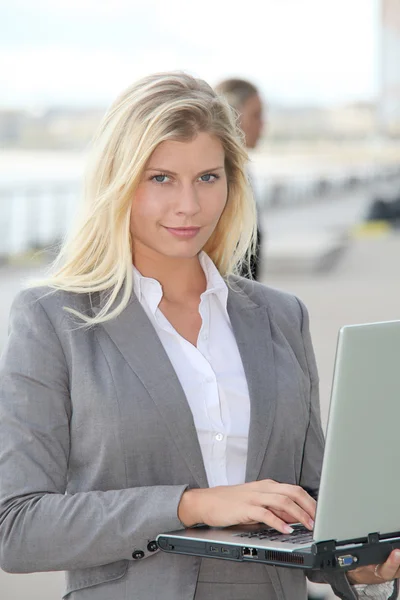 Блондинка бізнес-леді з портативним комп'ютером — стокове фото