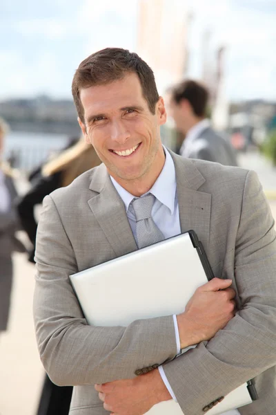 Businessman standing outdoors in the entrance of international fair — Stock Photo, Image