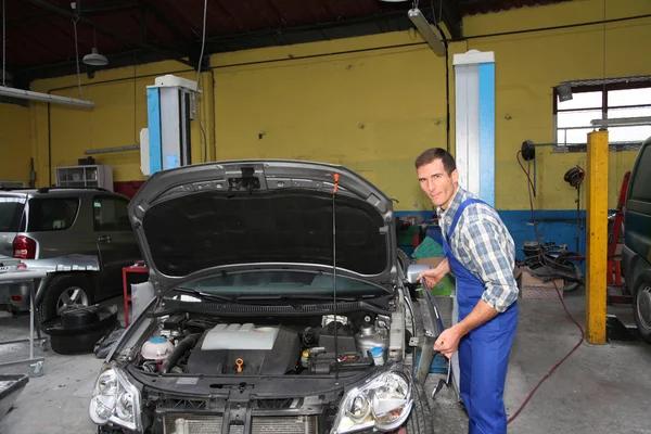 Reparador trabajando en vehículo en garaje — Foto de Stock