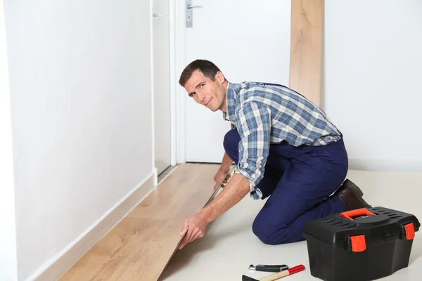 Zbliżenie rzemieślnik instalacja podłogi w pokoju — Zdjęcie stockowe
