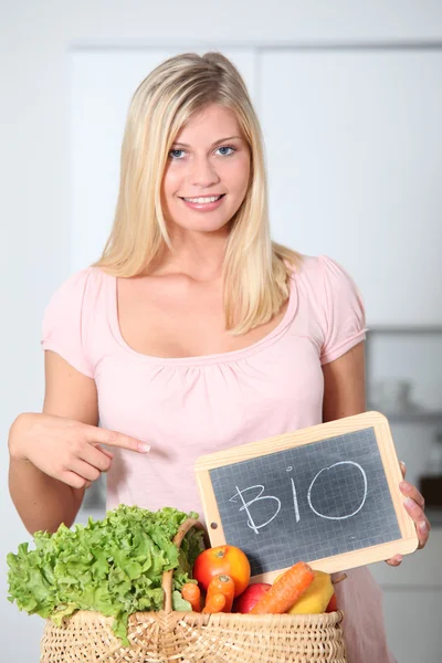 Mulher sorridente segurando cesta de comida orgânica — Fotografia de Stock