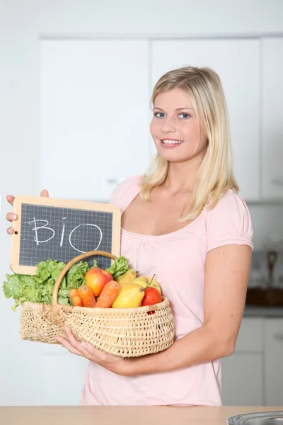 Mulher sorridente segurando cesta de comida orgânica — Fotografia de Stock