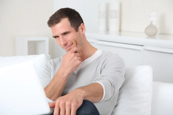 Close-up de homem adulto sentado no sofá com computador portátil — Fotografia de Stock