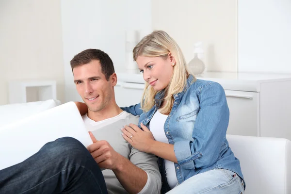 Closeup of couple sitting in sofa surfing on internet — Stock Photo, Image