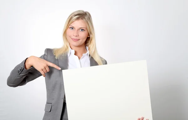 Empresária segurando painel branco — Fotografia de Stock