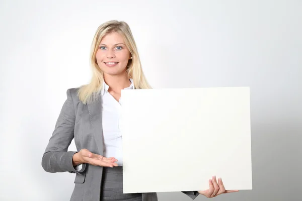 Empresária segurando painel branco — Fotografia de Stock