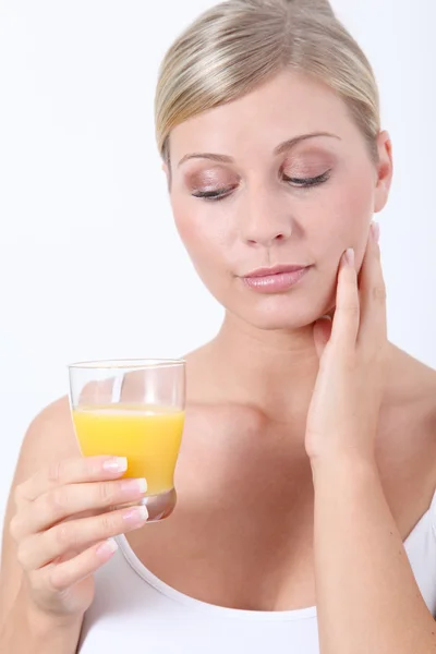 Mulher loira bonita segurando vidro de suco de laranja — Fotografia de Stock