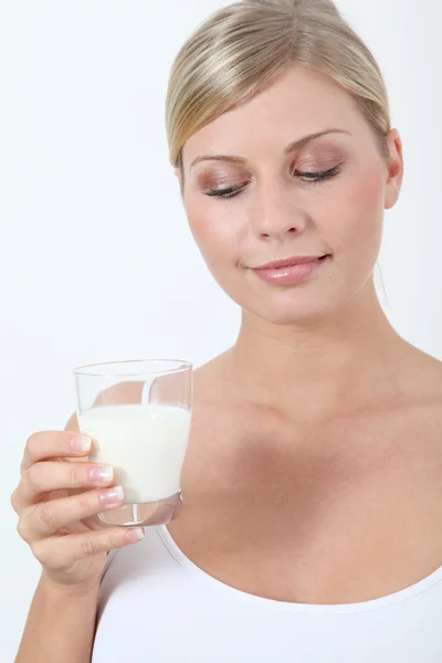 Beautiful blond woman holding glass of milk — Stock Photo, Image