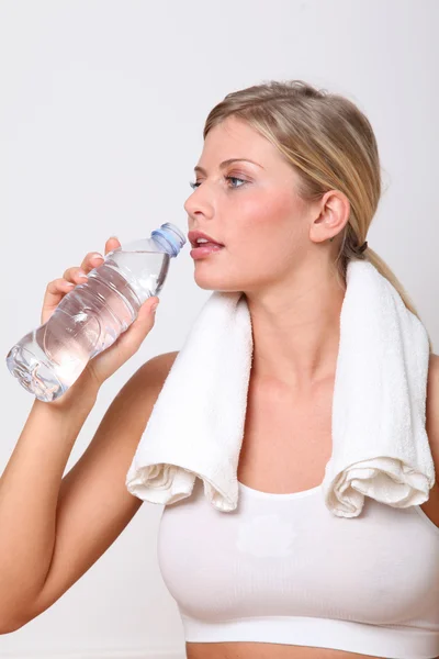 Mulher loira bebendo água após o exercício — Fotografia de Stock