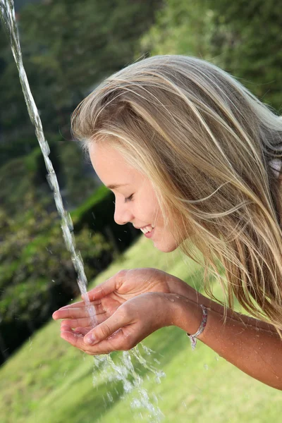 Blond girl drinking water from fountain — Stock Photo, Image