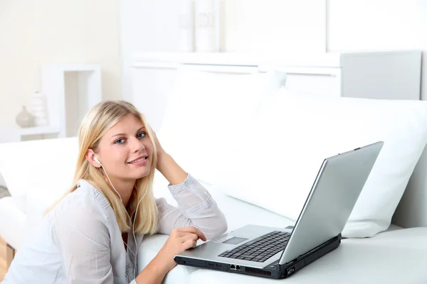 Kulaklık dizüstü bilgisayar önünde güzel sarışın bir kadınla — Stok fotoğraf