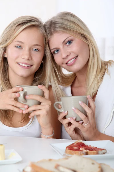 Mulher loira e menina loira tomando café da manhã — Fotografia de Stock