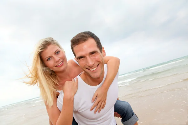 Casal feliz desfrutando de férias em uma praia de areia — Fotografia de Stock