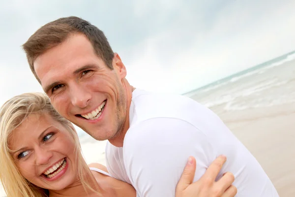 Casal se divertindo em uma praia de areia — Fotografia de Stock