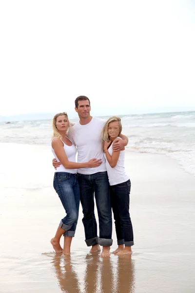 Família andando de mãos dadas em uma praia de areia — Fotografia de Stock