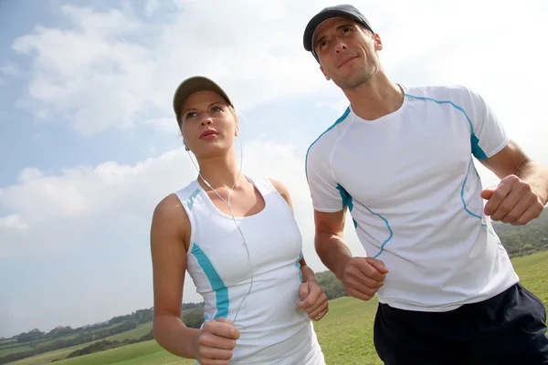 Couple running outside on a sunny day — Stock Photo, Image