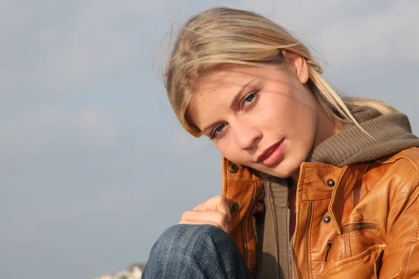 Nahaufnahme einer Frau, die im Herbst am Strand sitzt — Stockfoto