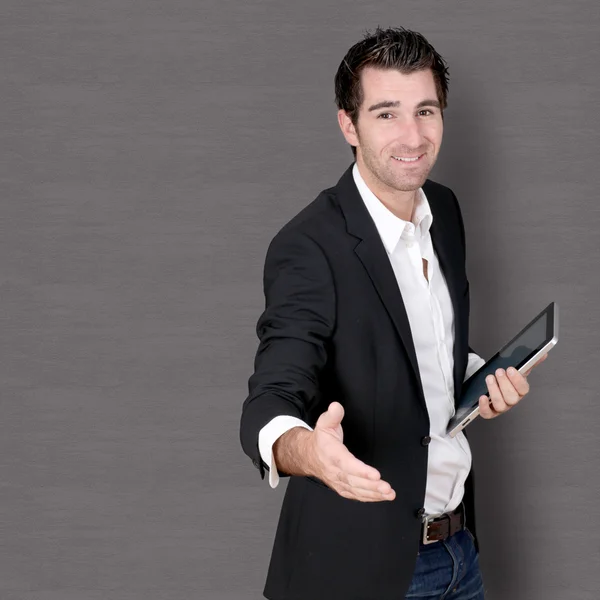 Salesman with tablet giving handshake — Stock Photo, Image