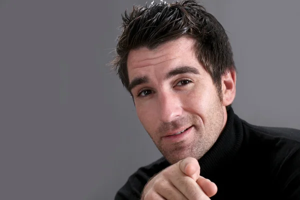 Man on black background pointing at camera — Stock Photo, Image