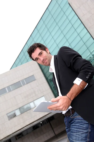 Man using electronic tablet in front of modern building — Stock Photo, Image