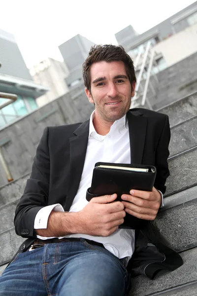 Businessman sitting in stairs out in town — Stock Photo, Image