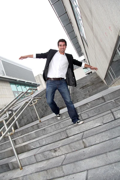 Man running downstairs with stretched arms — Stock Photo, Image