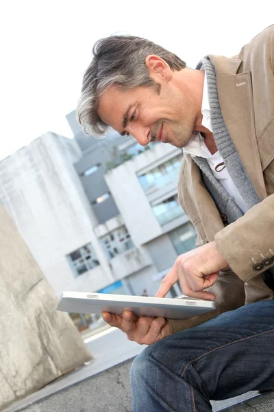 Guapo chico en la ciudad usando tableta electrónica — Foto de Stock