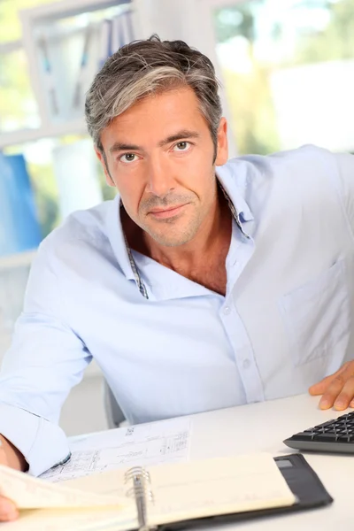 Handsome office worker writing notes on agenda — Stock Photo, Image