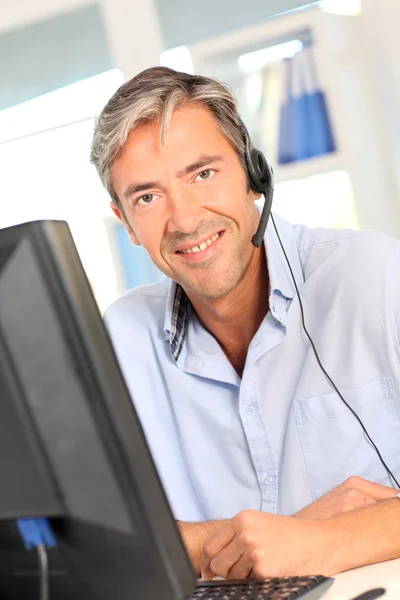 Customer service employee with headphones — Stock Photo, Image