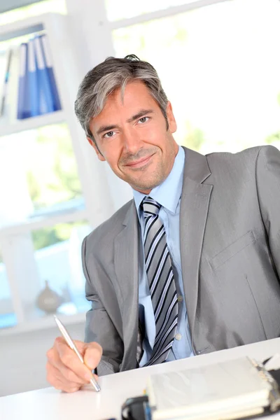 Lachende zaakvoerder in office — Stockfoto