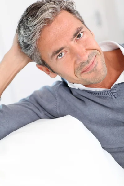 Bonito homem relaxando no sofá em casa — Fotografia de Stock