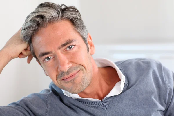 Bonito homem relaxando no sofá em casa — Fotografia de Stock