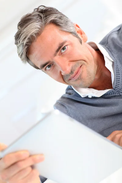 Homme de 40 ans à la maison utilisant une tablette électronique — Photo